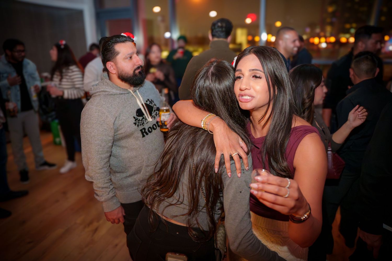 A lively indoor party scene with people mingling and socializing.