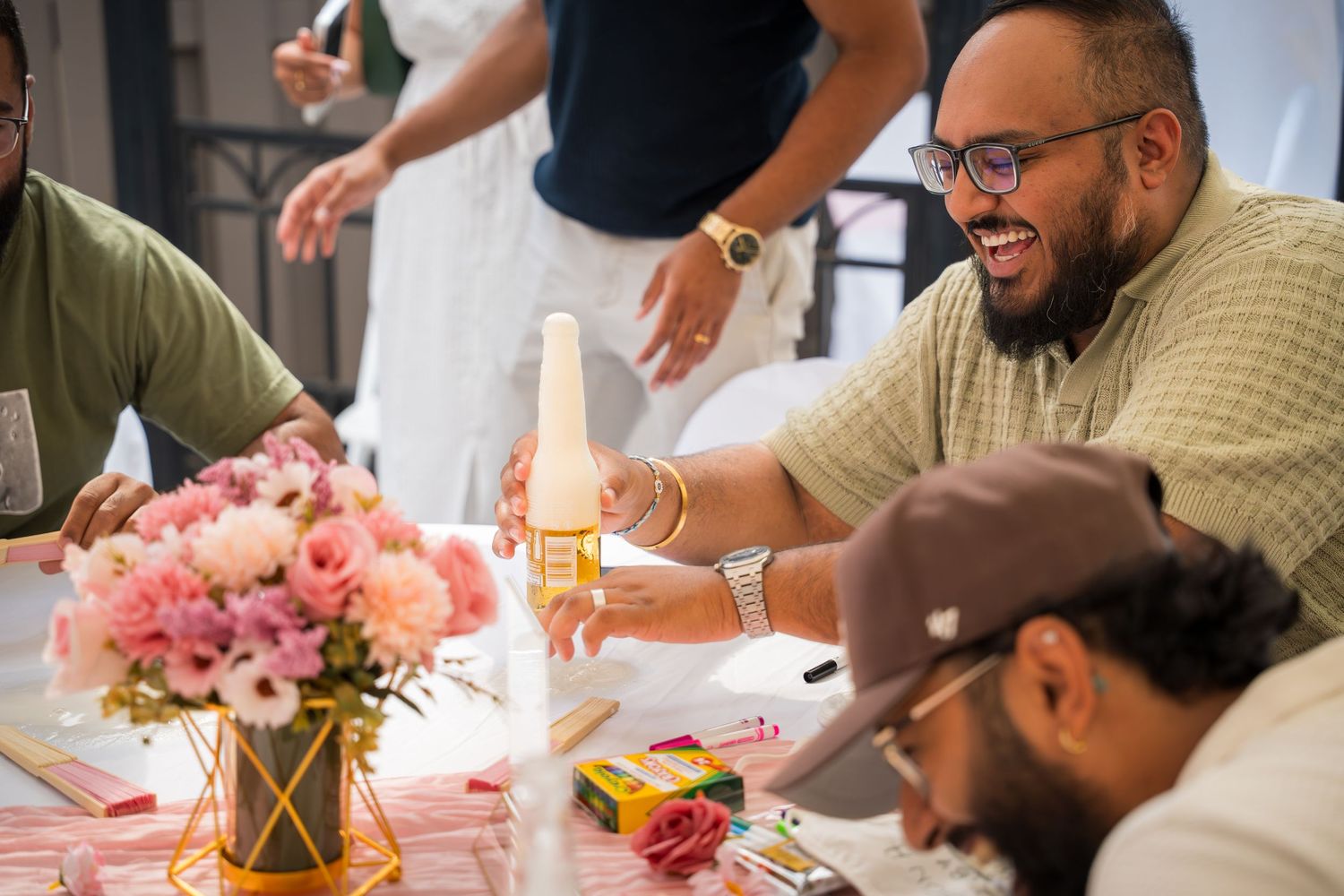 Guests mingling at a celebration with drinks and decorative table settings.