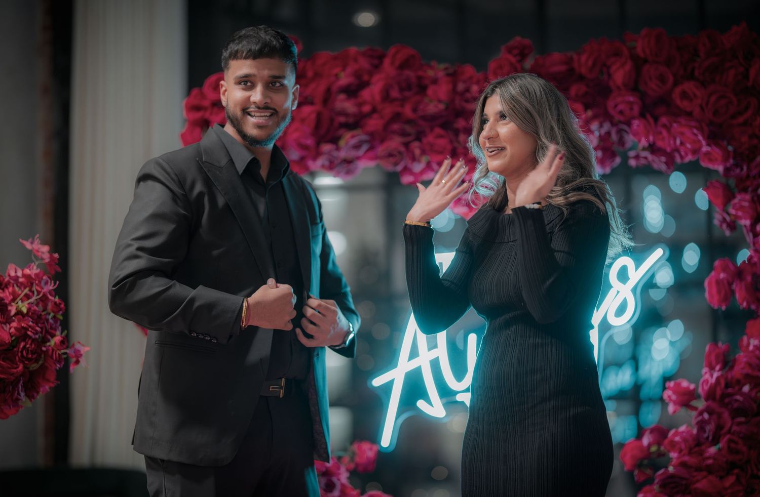 A romantic scene with neon blue lighting and red rose decorations creating an intimate atmosphere.