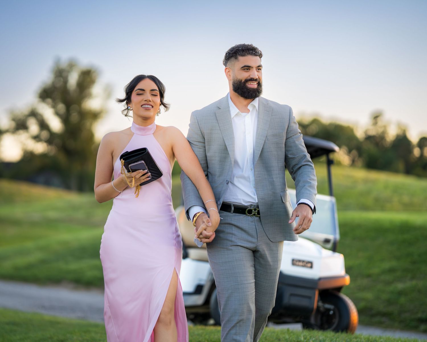 A romantic proposal scene unfolds on a golf course path at dusk.