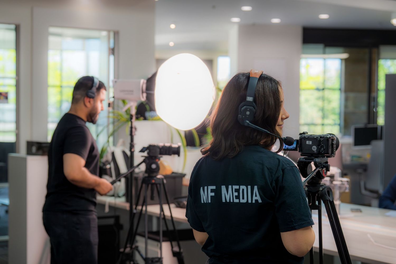 NF Media crew filming a professional video production shoot indoors with studio lighting equipment and cameras.