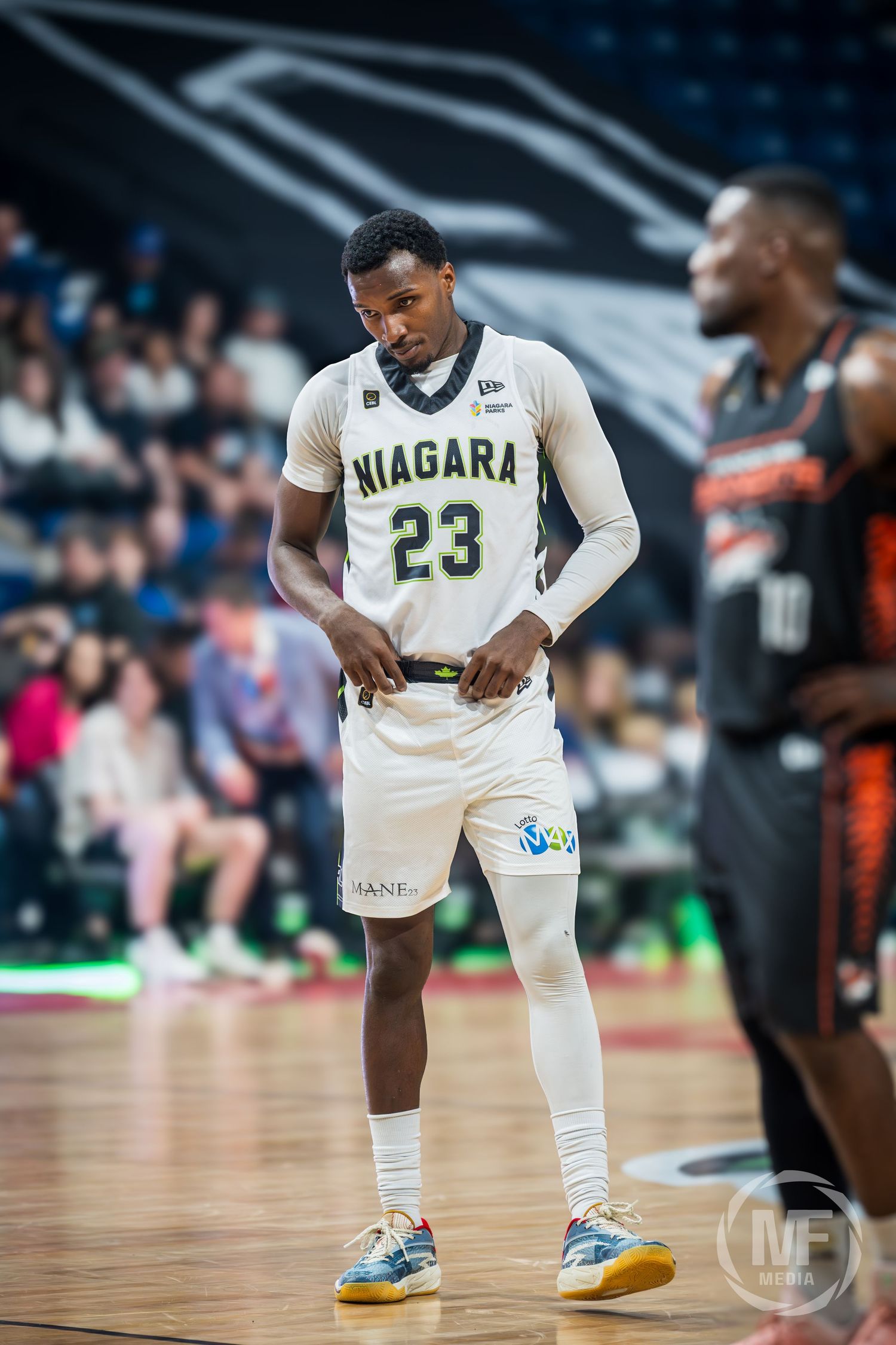 Niagara basketball player number 23 in white uniform stands on court during game.