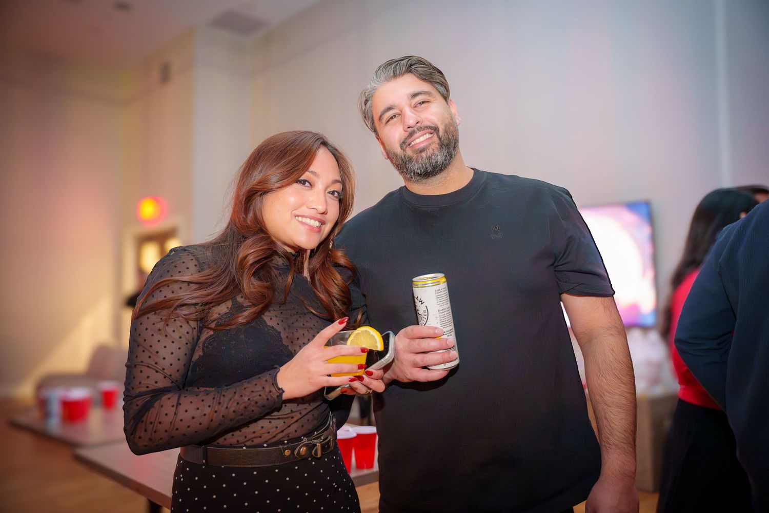 Friends enjoying drinks and conversation at an indoor social gathering.