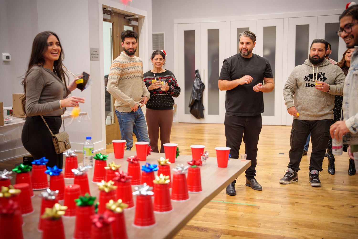 Red solo cups arranged in rows on a white floor during an indoor gathering.