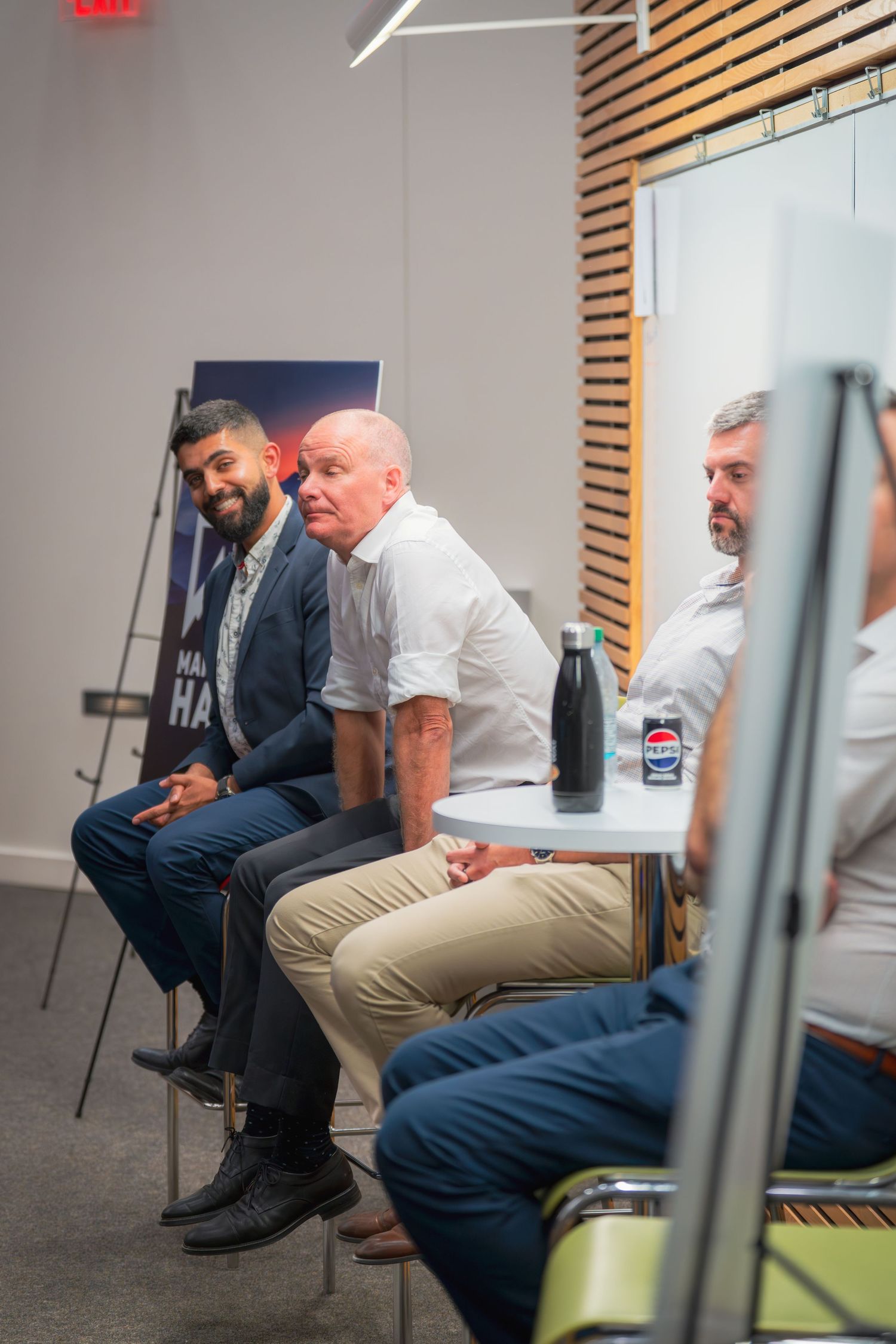 Speakers seated on stage during a professional presentation event.