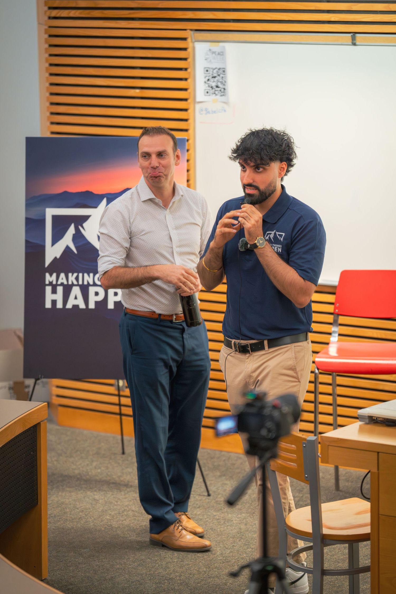Meeting room with 'Making Things Happen' banner and wooden wall panels.