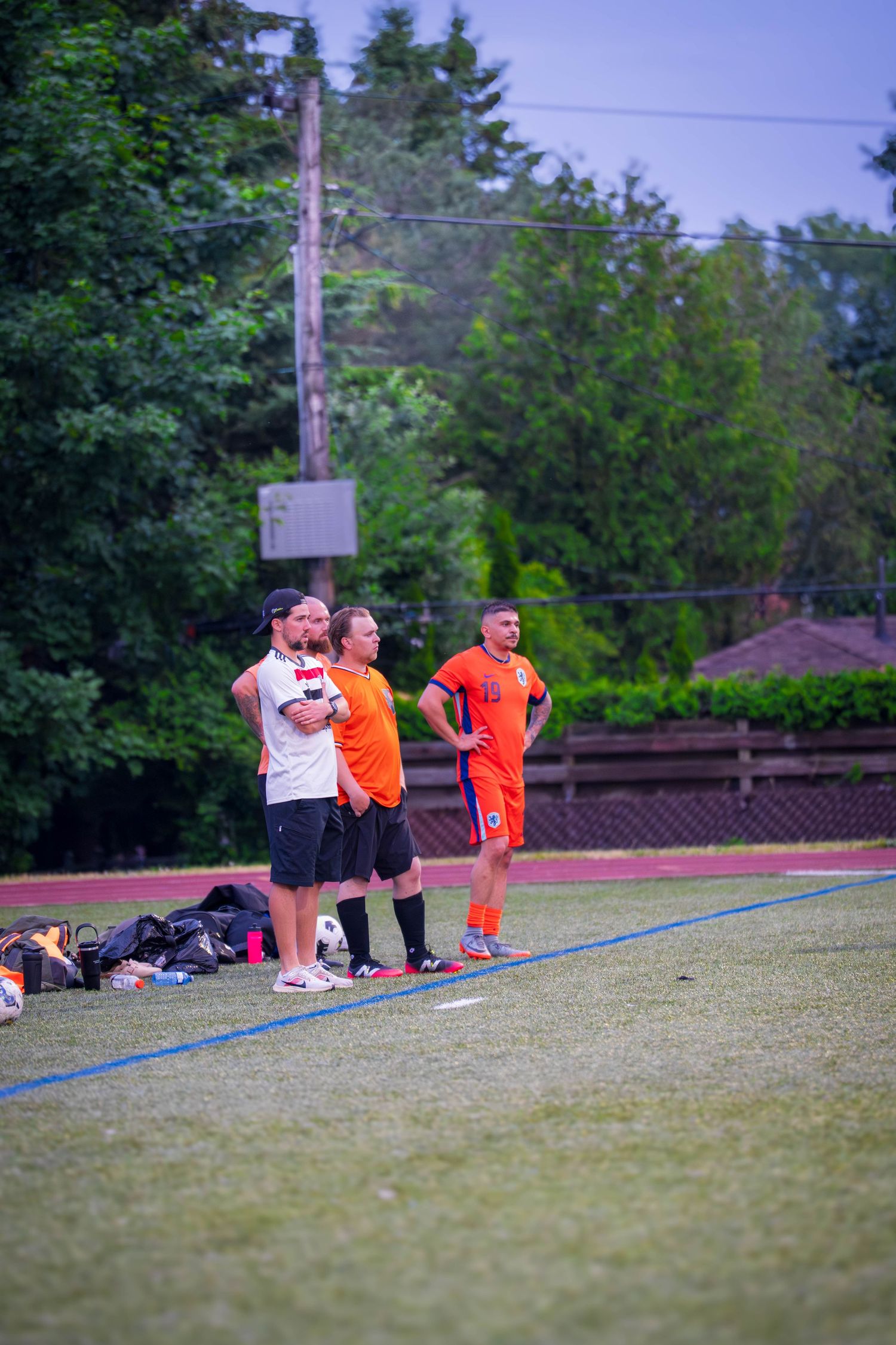 Players and spectators watch from sideline during soccer match.