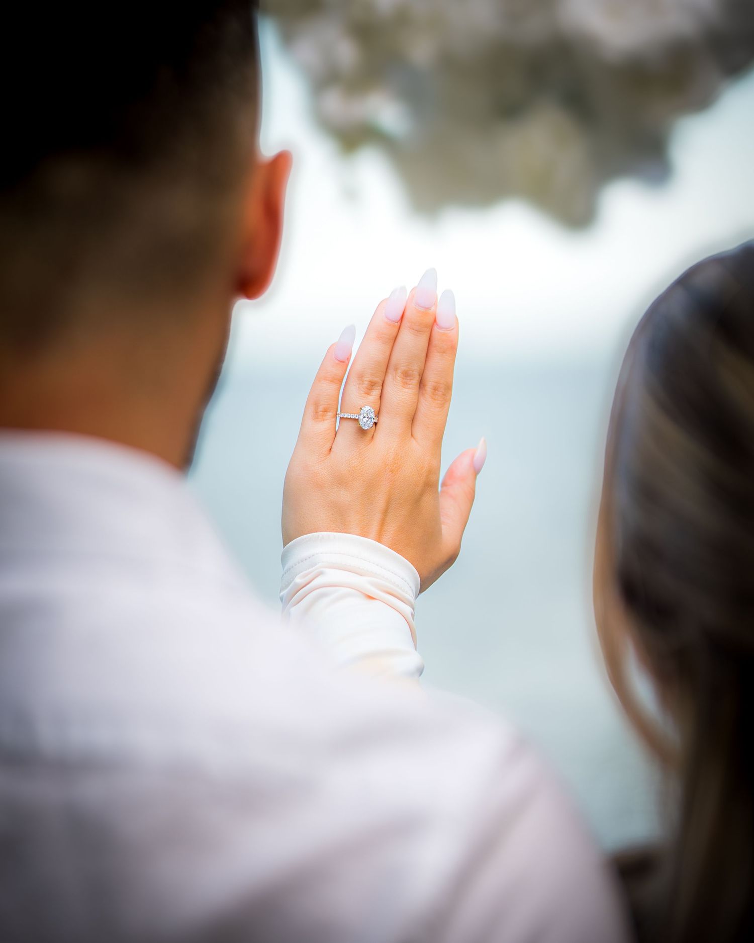 Several raised hands are shown in a soft focus blur effect against a light background.