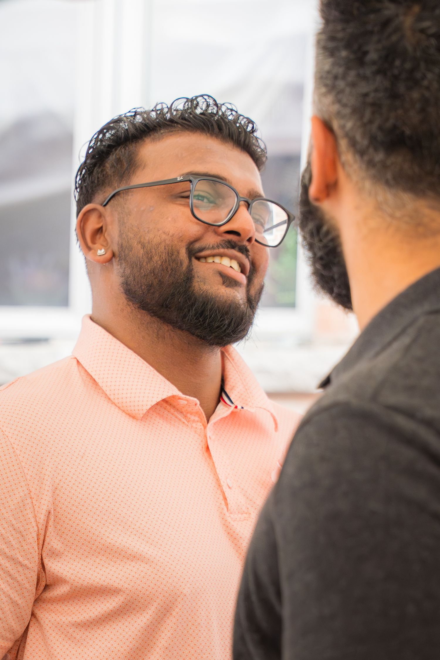 Two people sharing a joyful moment in peach and black attire.