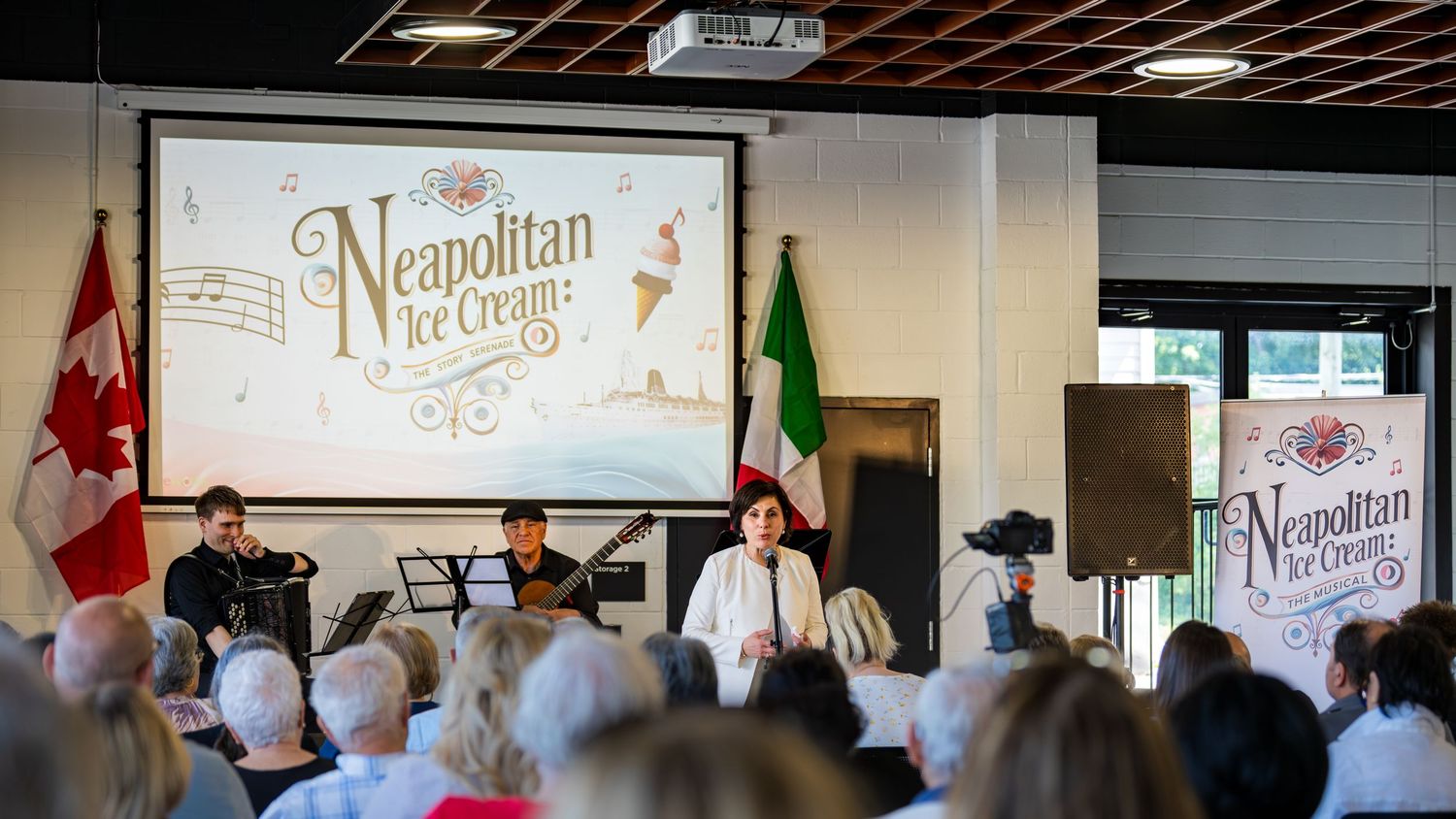 Panelists speaking at Neapolitan Ice Cream cultural event with audience, Canadian and Italian flags displayed.