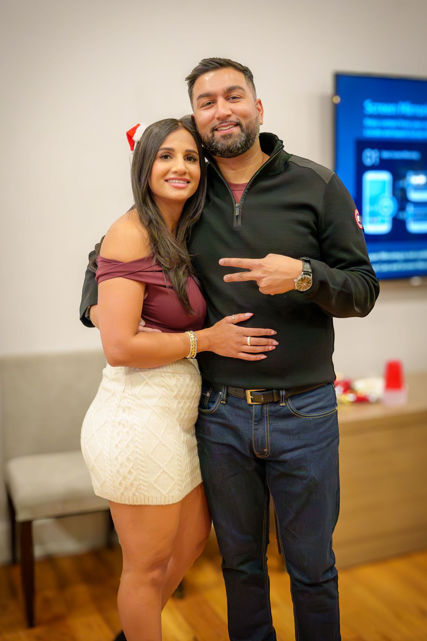 People enjoying themselves at an indoor party with hardwood floors and white walls.