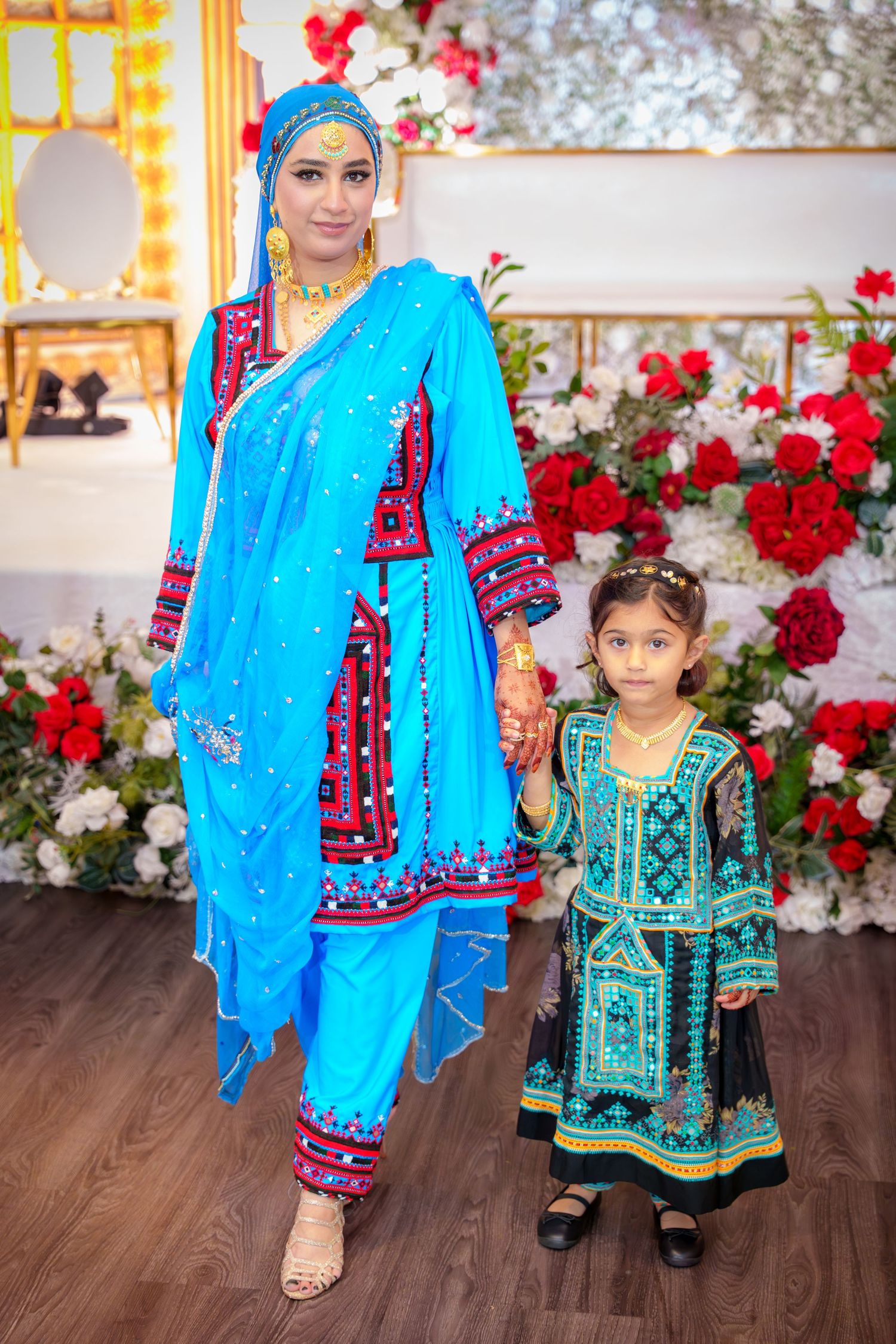 Traditional Pakistani or Indian wedding attire featuring bright blue and green ethnic dresses with embroidery.
