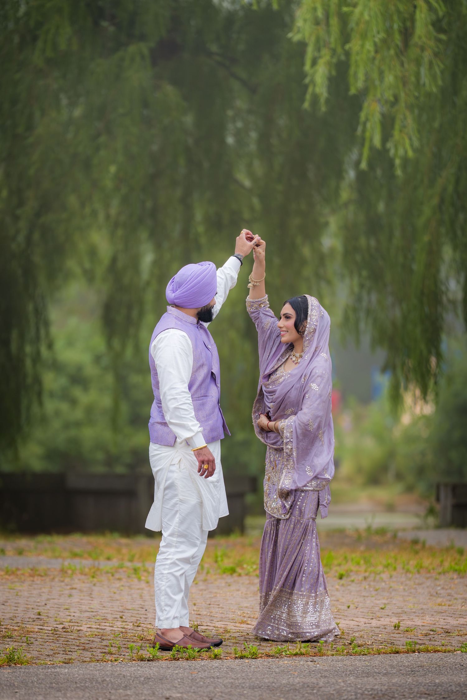 A romantic dance sequence captured under weeping willow trees with couple in coordinated purple attire.