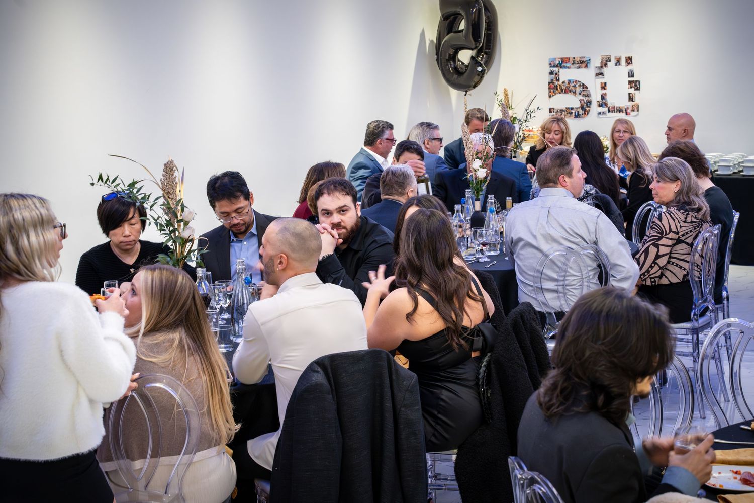Attendees network and socialize during a corporate celebration event.