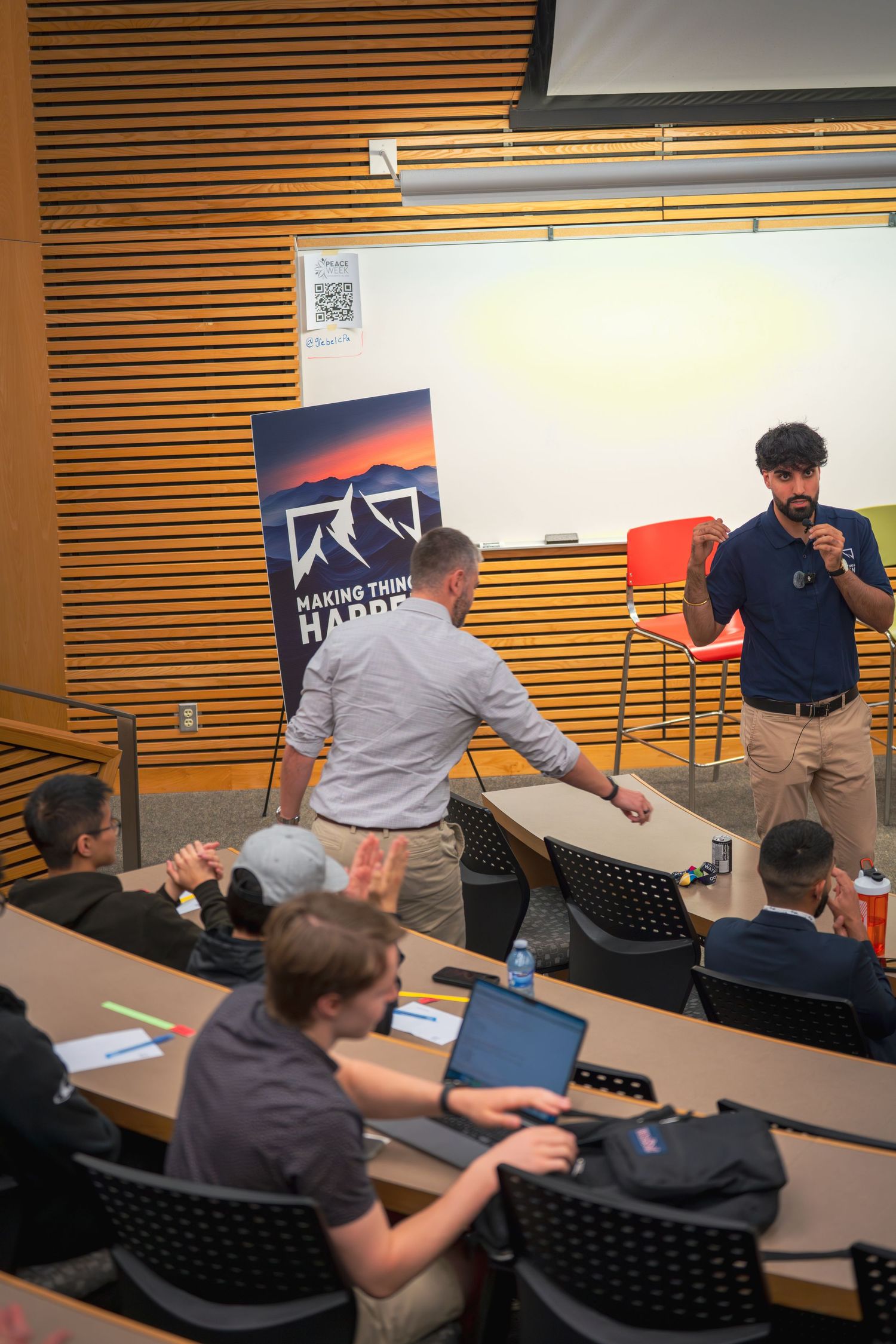Attendees participating in a business meeting with laptops in a corporate conference space.