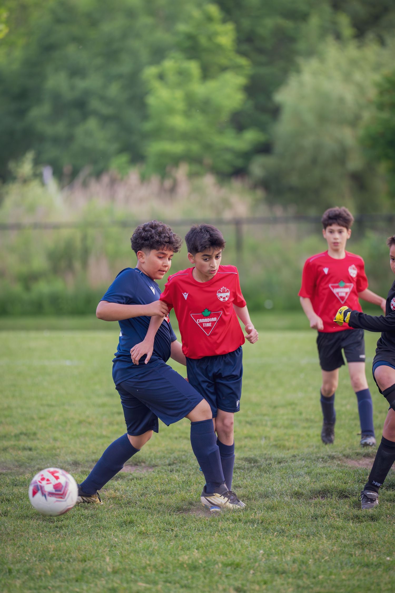 Young soccer players practice their footwork and drills on a grass field during training.