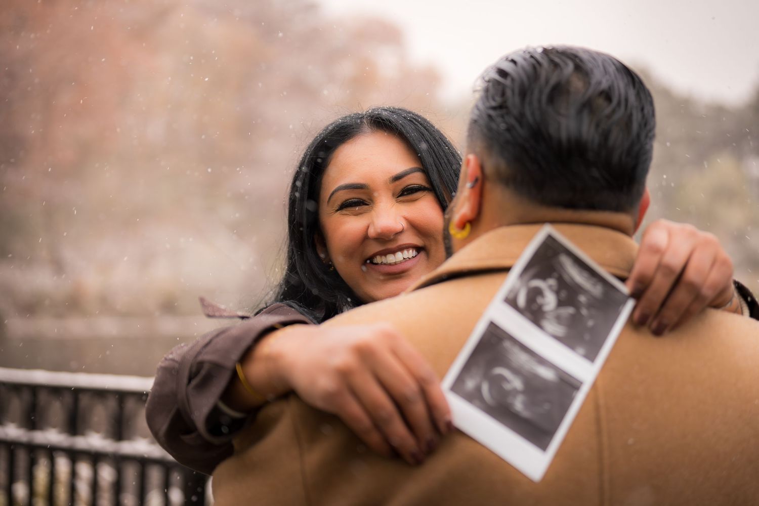 Couple sharing a tender moment while holding an ultrasound photo.