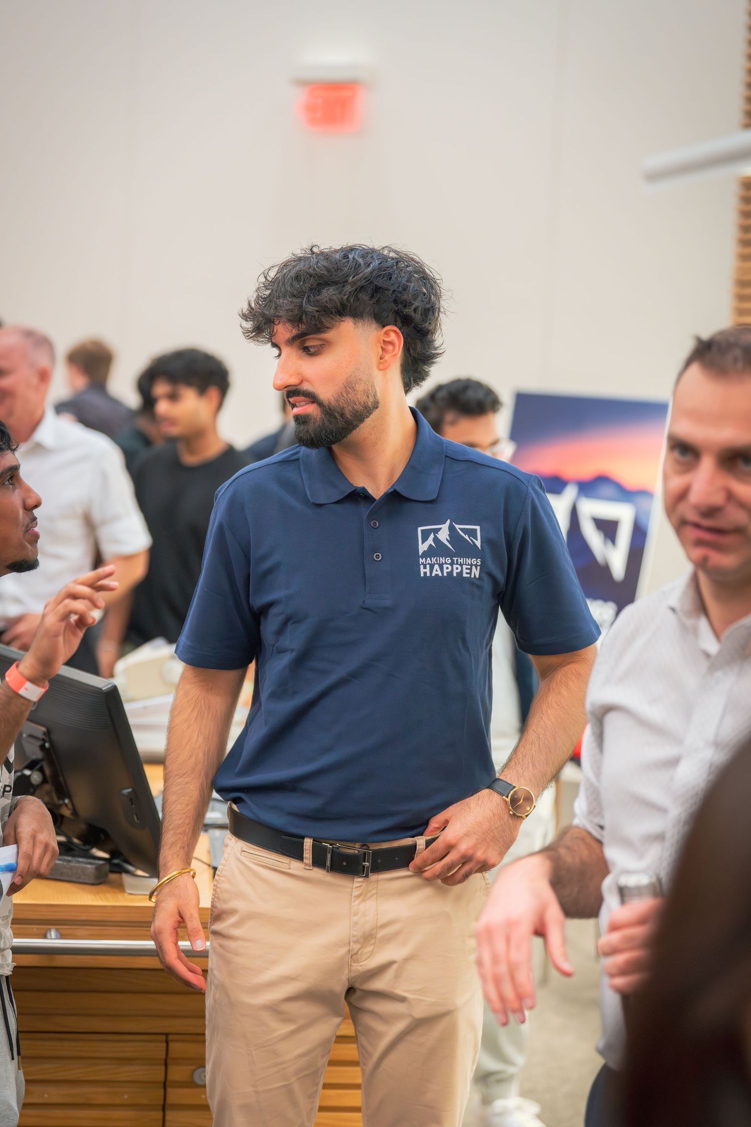 Presenter wearing a branded navy polo and khaki pants gestures during a talk.