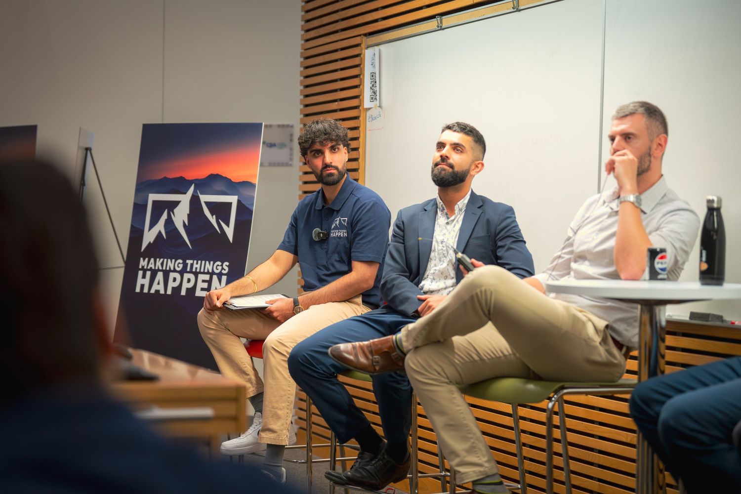 Panel discussion with 'Making Things Happen' banner visible in modern conference setting.