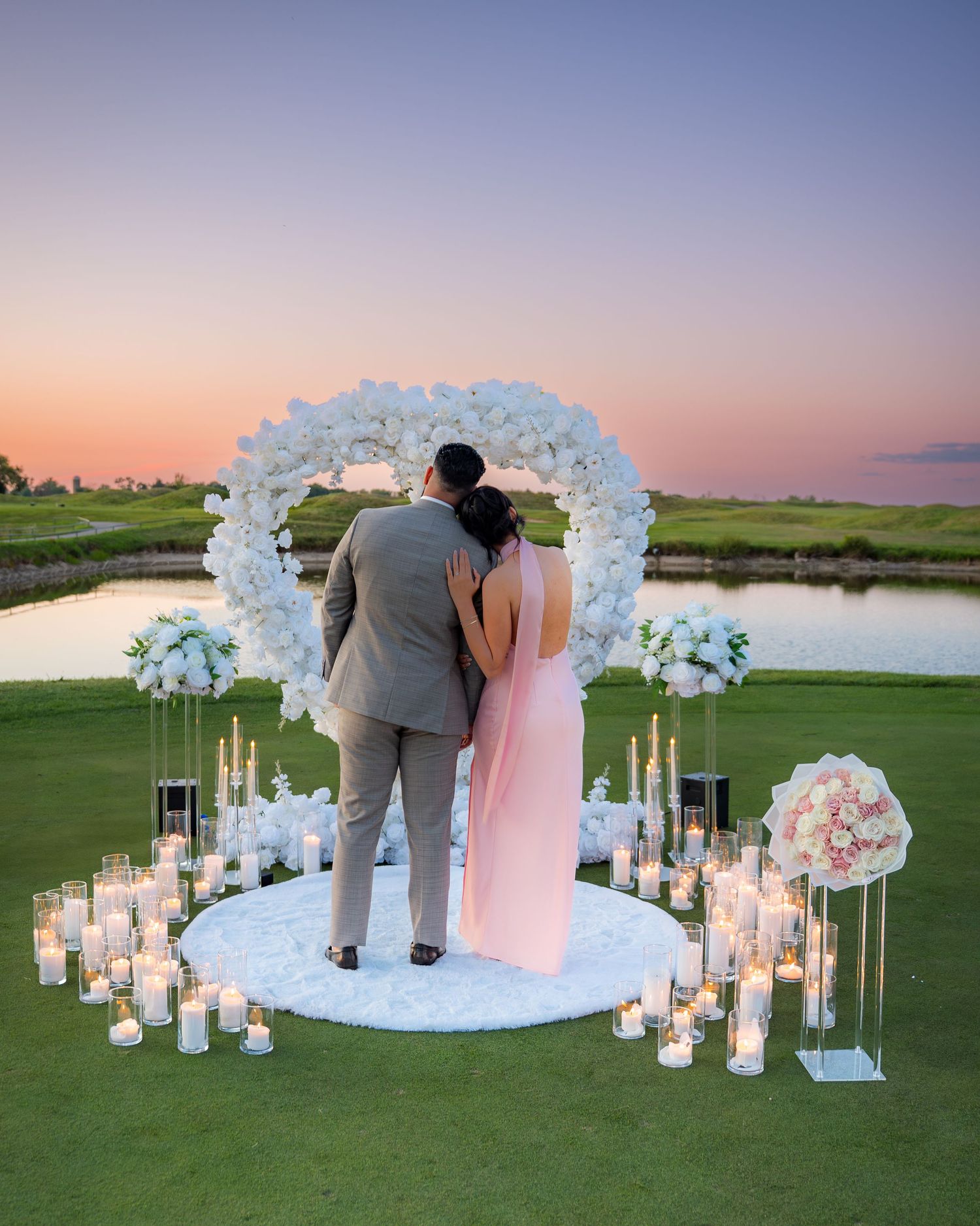 Couple admiring sunset view after romantic proposal on golf course.