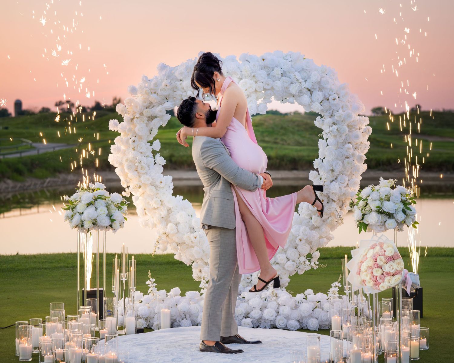 Sunset wedding scene with romantic lighting and white floral arch decorations.