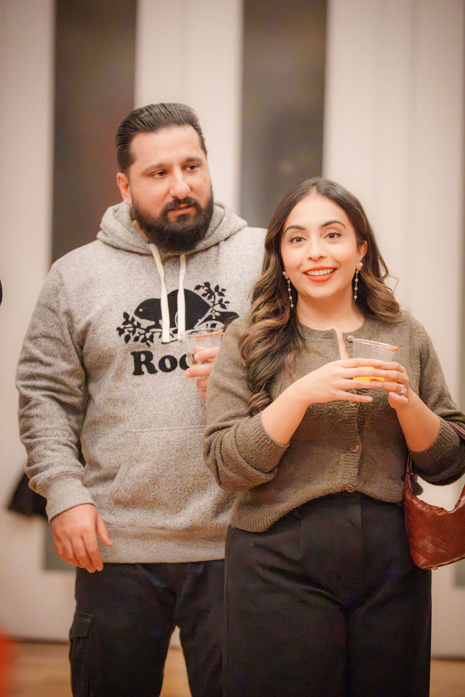 Two people in casual attire sharing a moment at an indoor event.