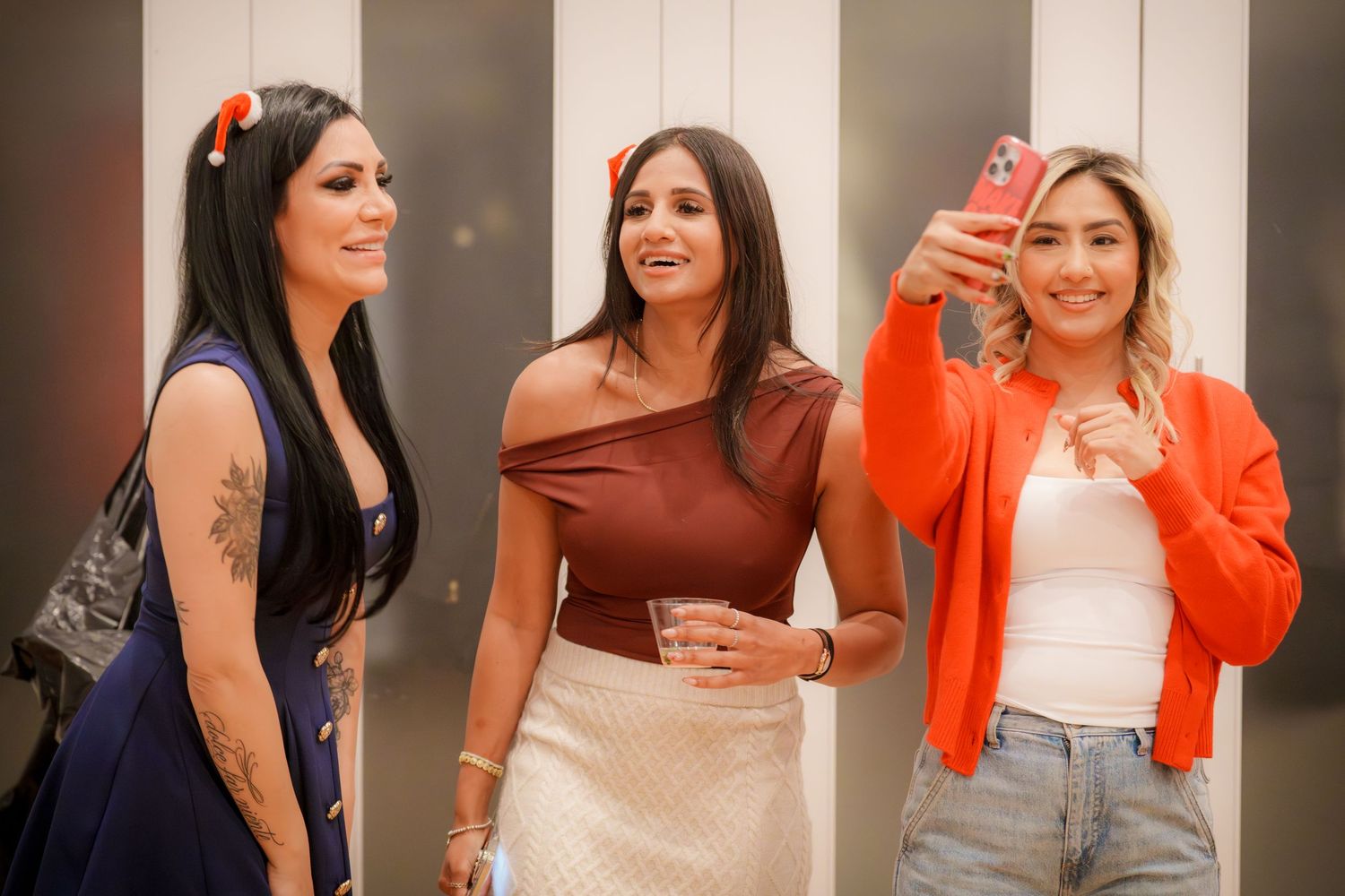 Women in casual attire socializing at an indoor party.