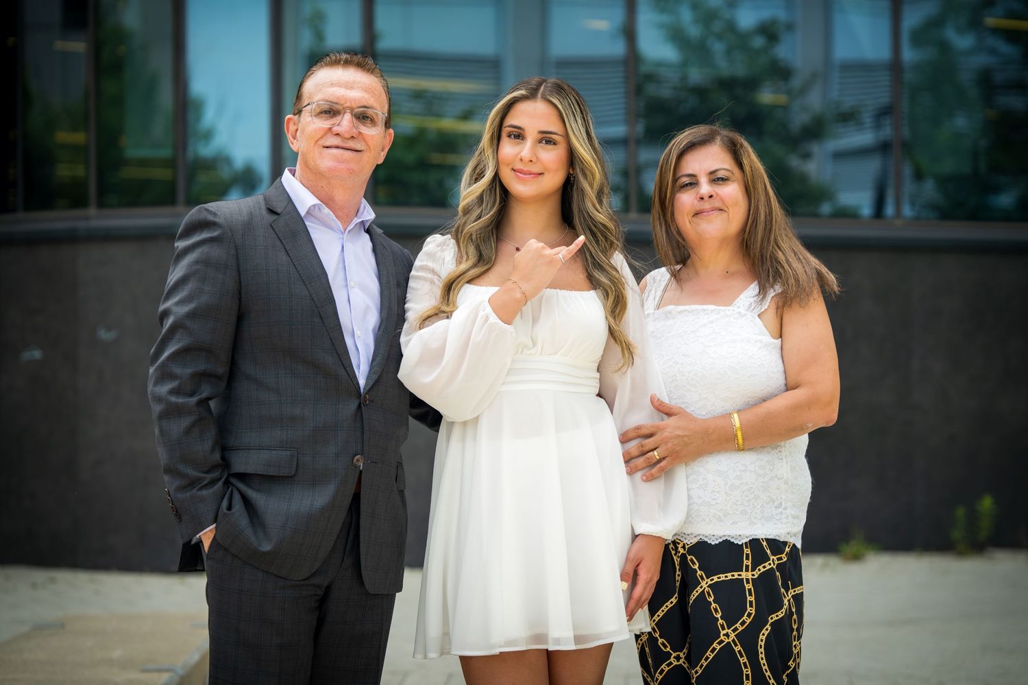 Family members pose together in coordinated outfits against urban backdrop.