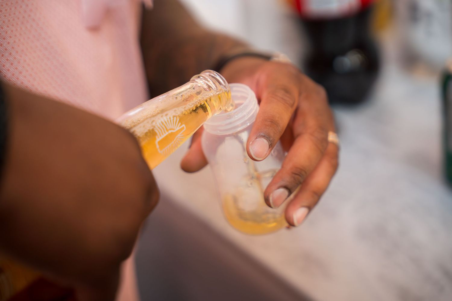 Close-up shot of hands holding glasses of beer in a celebratory toast.