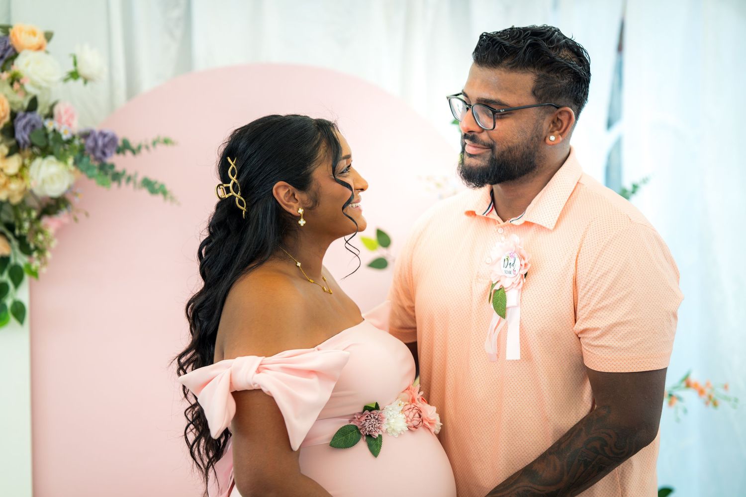A couple shares an intimate moment at a social gathering with soft lighting and decorative elements.