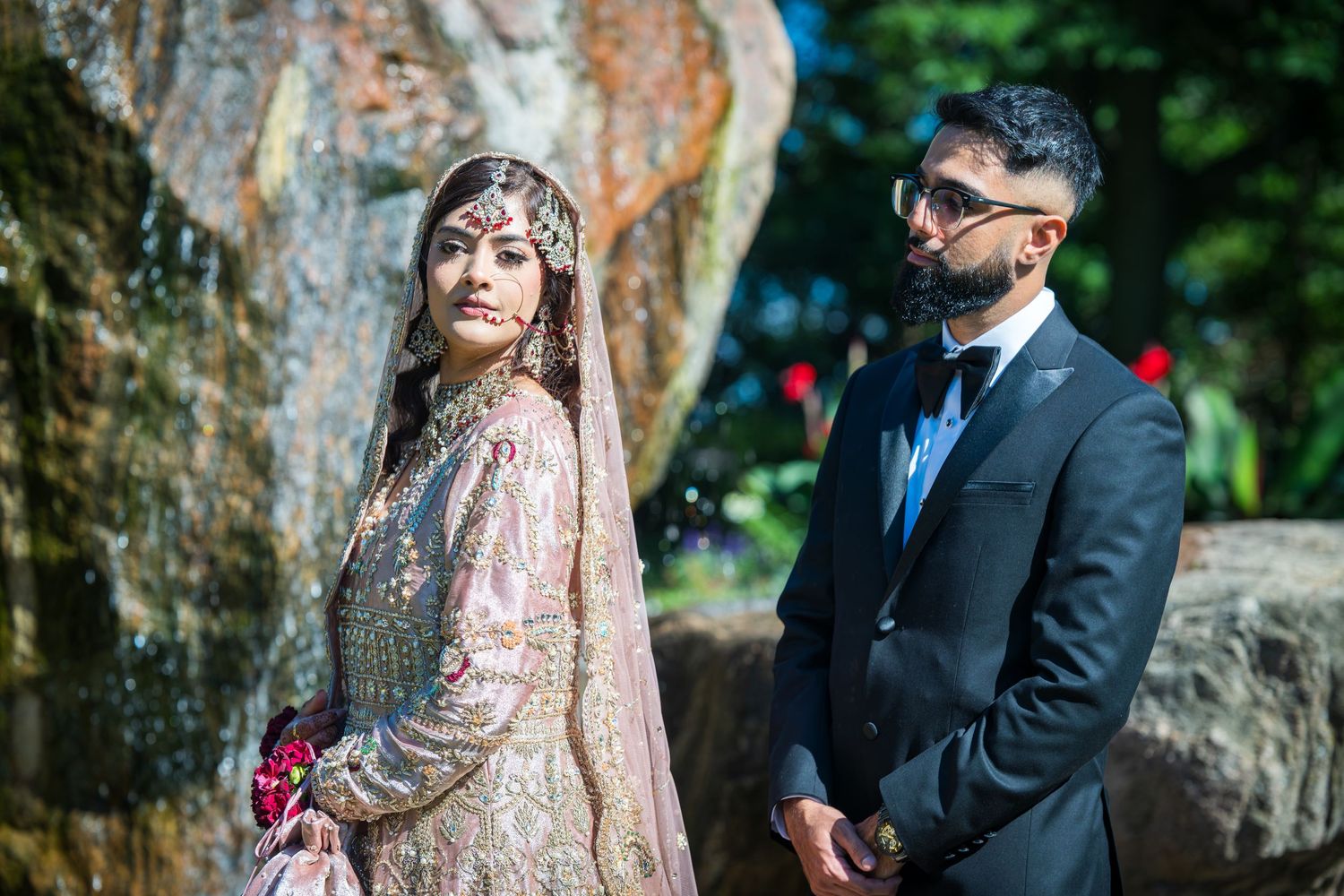 Elegant wedding photos against rustic stone wall backdrop with natural lighting.