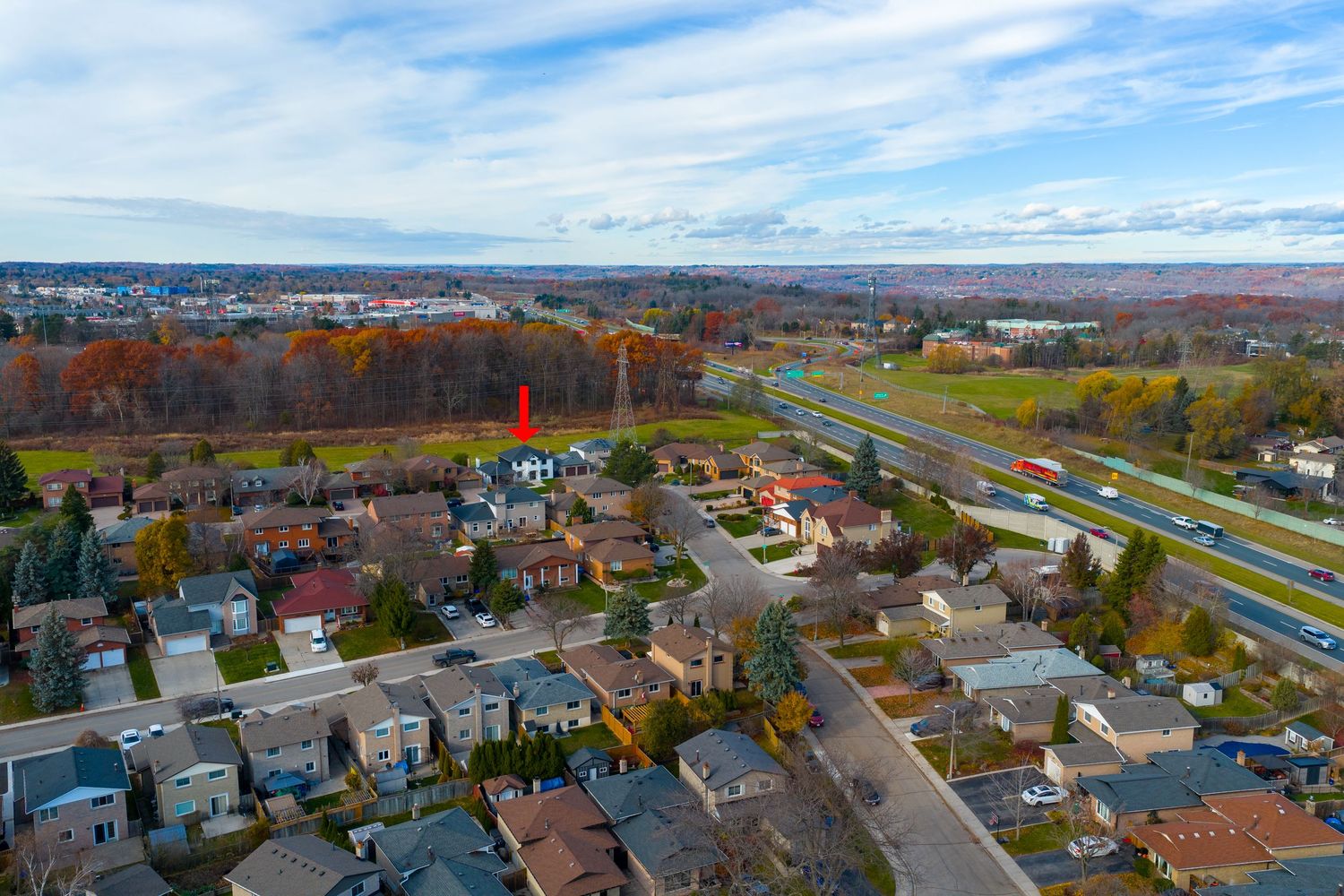 Aerial view of a residential neighborhood with fall foliage and highway intersection in Binghamton, New York.