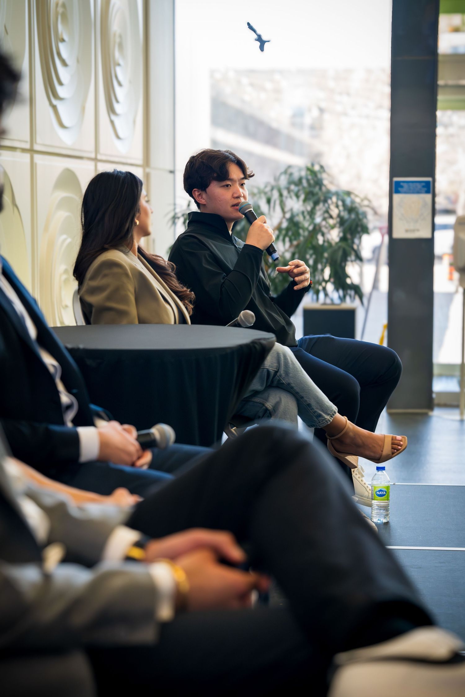 Attendees listen intently during a conference session in a modern meeting space.