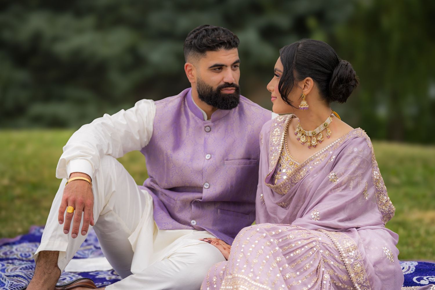 Candid moments captured of couple in traditional attire during outdoor photo session.