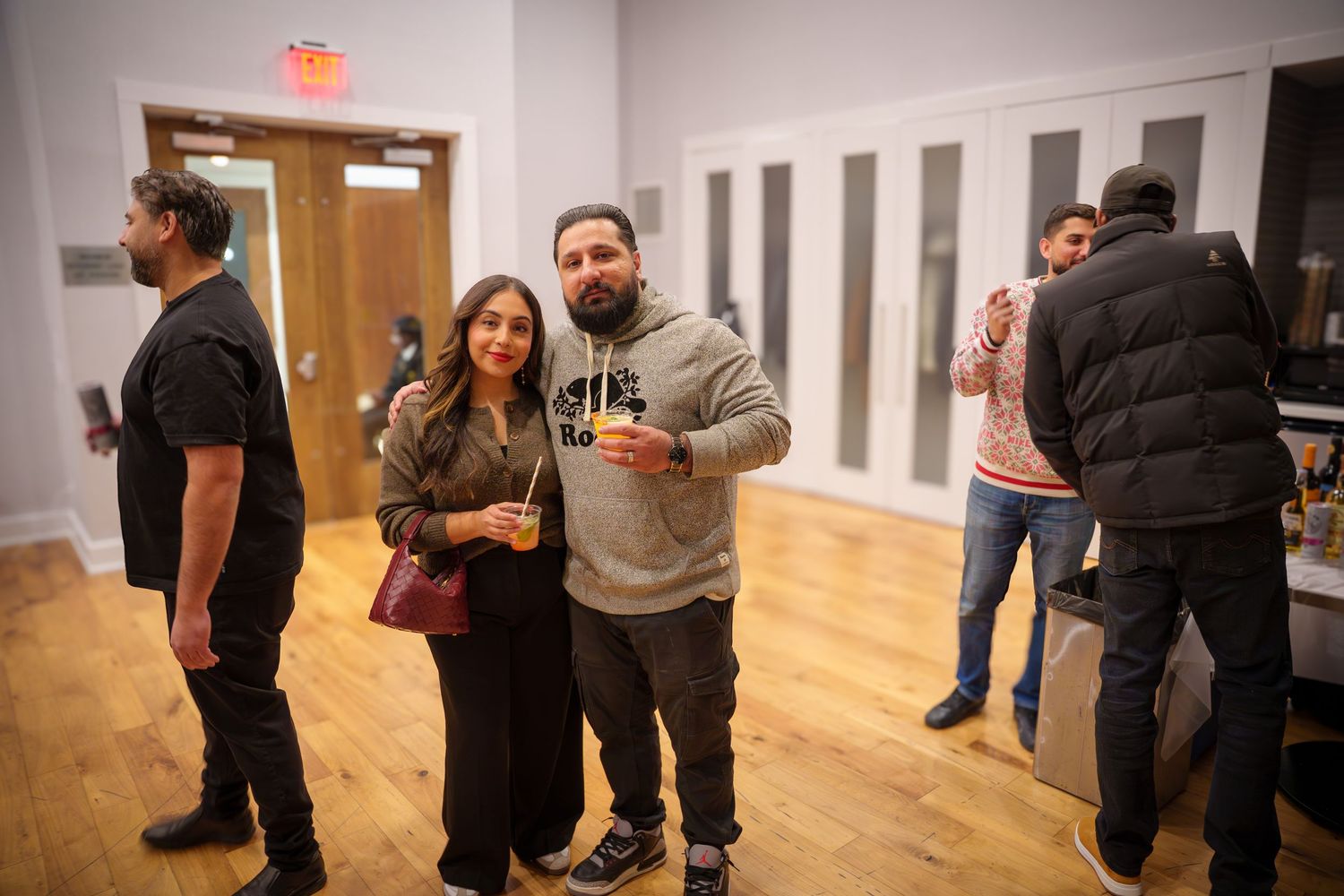 People enjoying a casual indoor gathering with red cups and wooden floors.