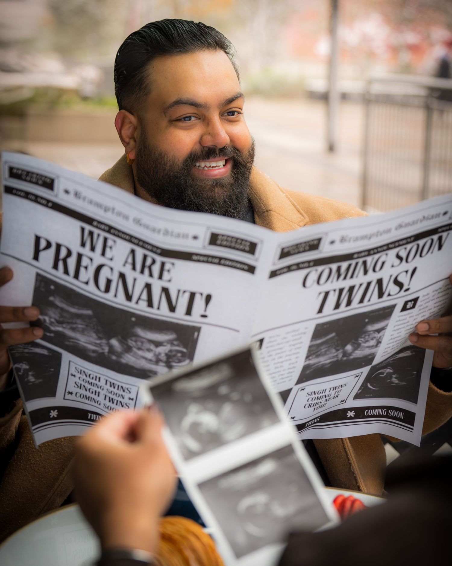 A series of custom newspaper-style wedding announcements being held and read.