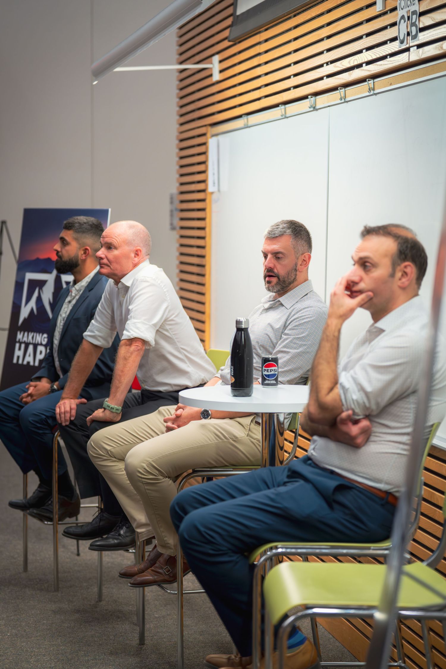 Row of speakers seated during a professional panel presentation event.