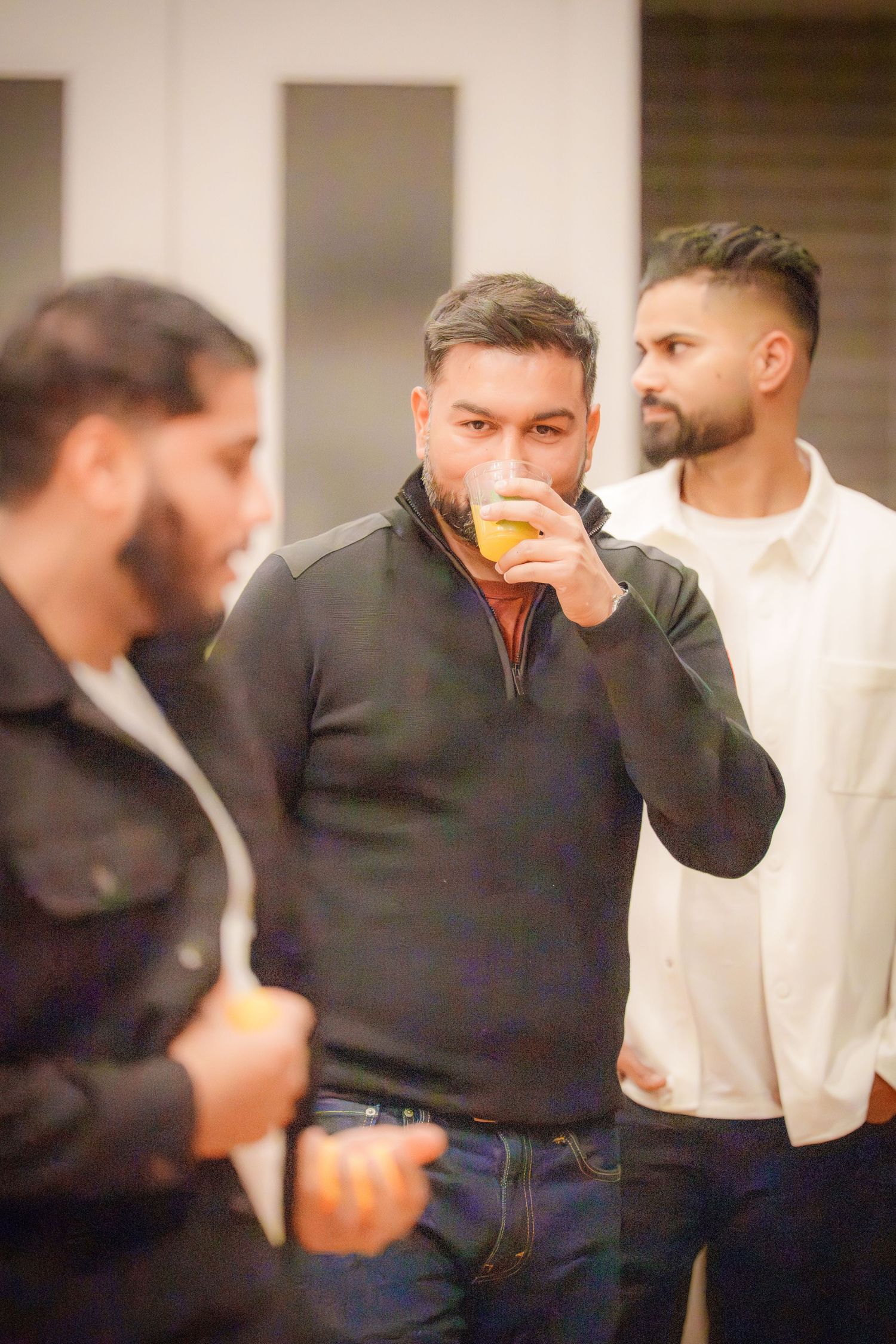 People gathered indoors wearing casual attire appear to be enjoying a social event.