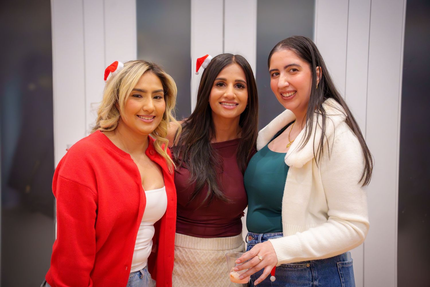 Group of friends smiling and posing together at an indoor party.