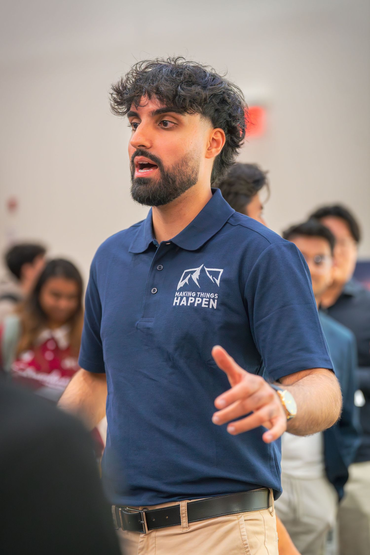 Animated speaker in company polo demonstrates point during presentation.