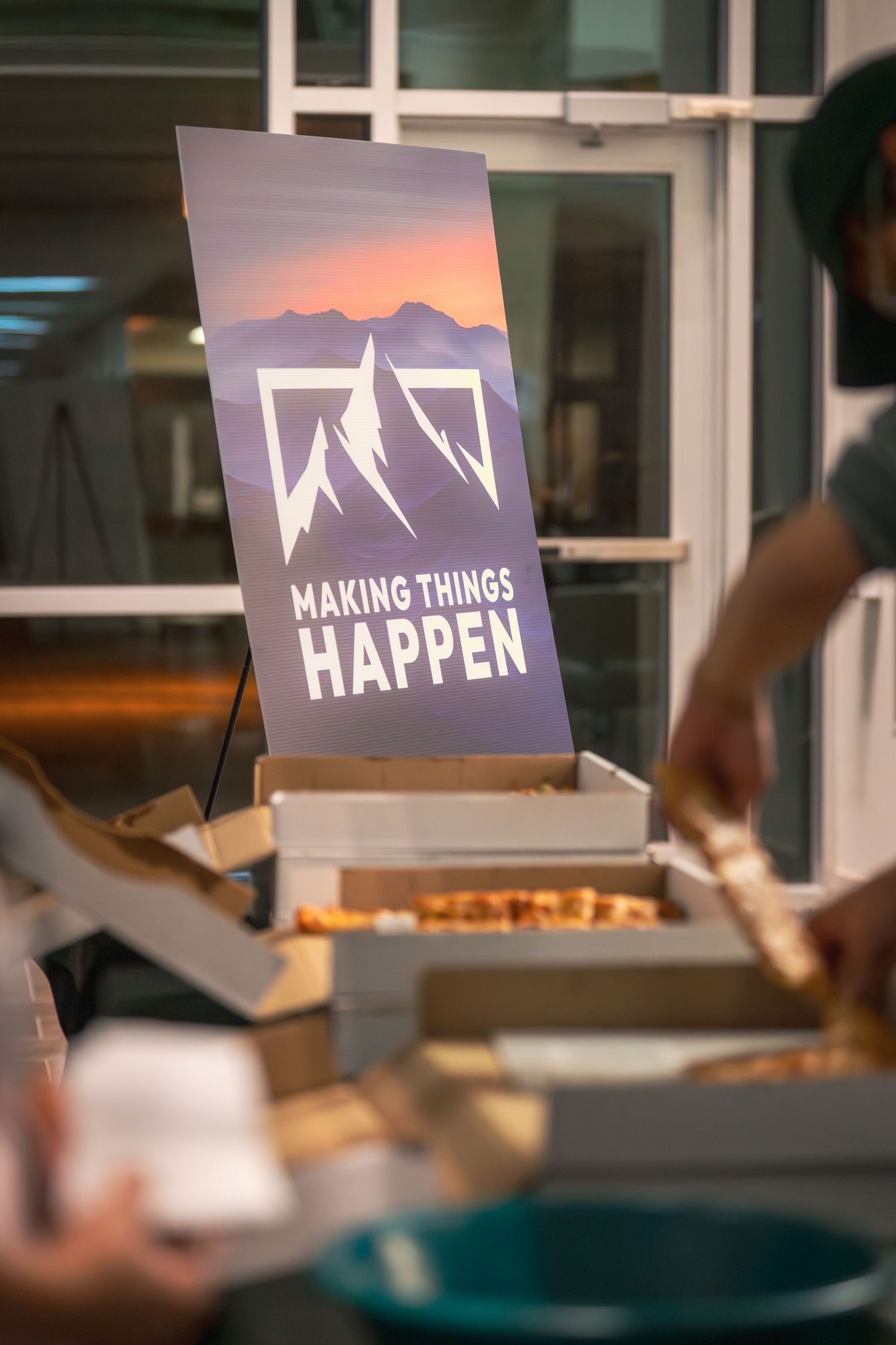 Marketing materials showing a mountain-inspired logo design with 'Making Things Happen' text.
