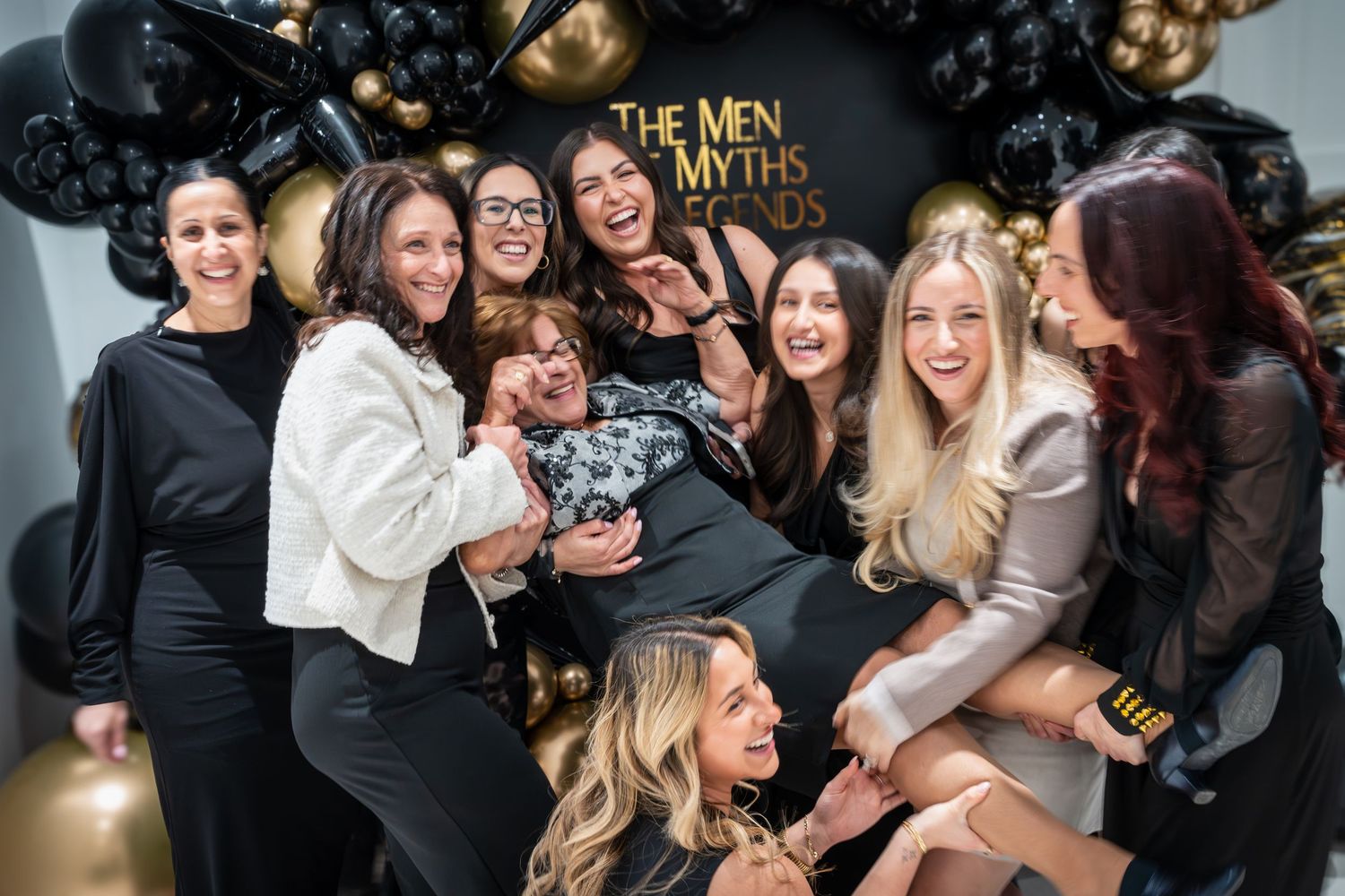 Candid party moments captured with guests laughing against festive balloon backdrop.
