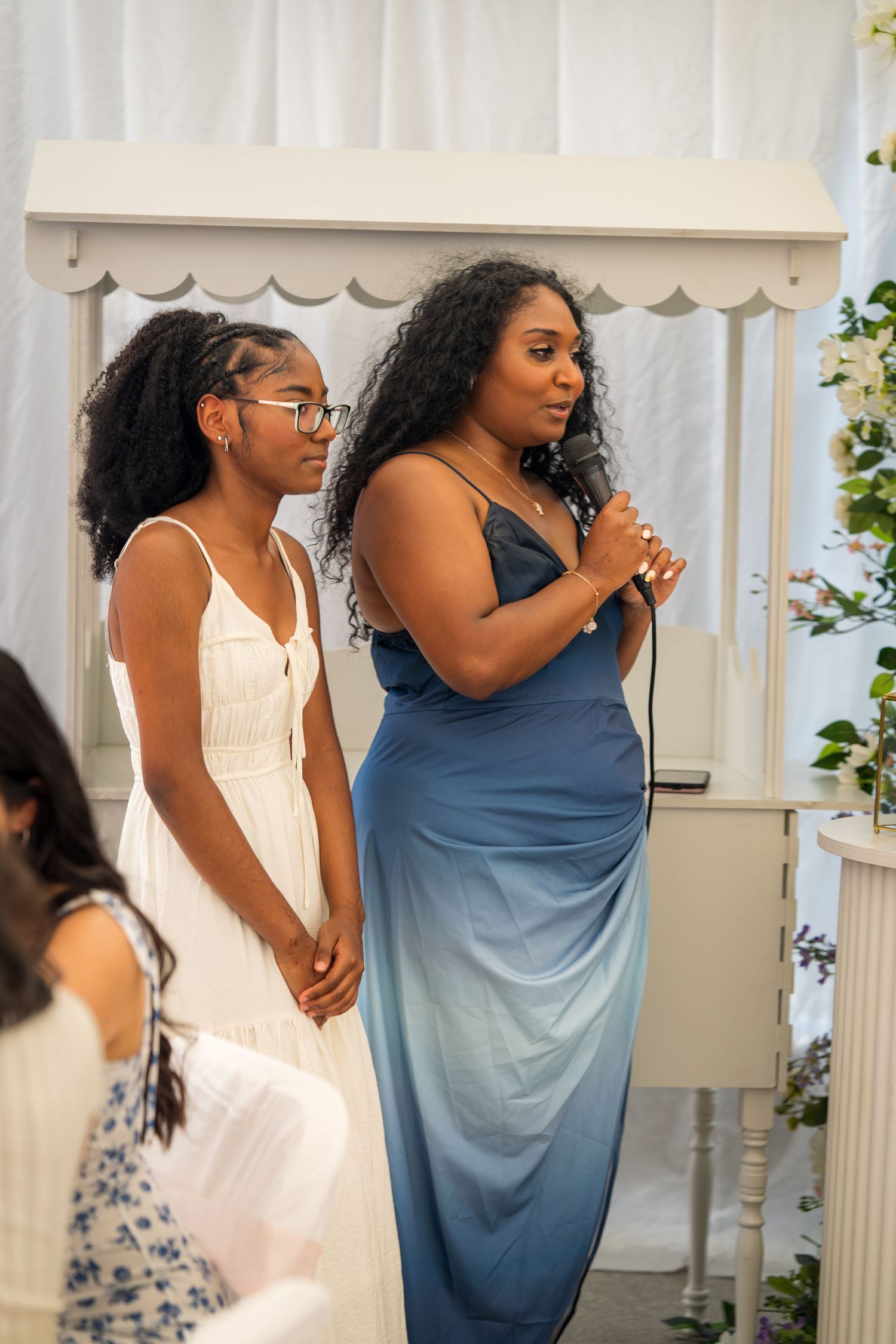 Two people in white and blue outfits share joyful moments during a celebration.