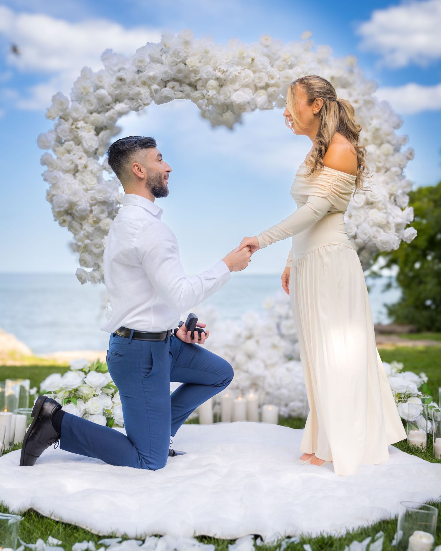 Dreamy outdoor proposal setting with white balloon decorations and candlelit pathway.