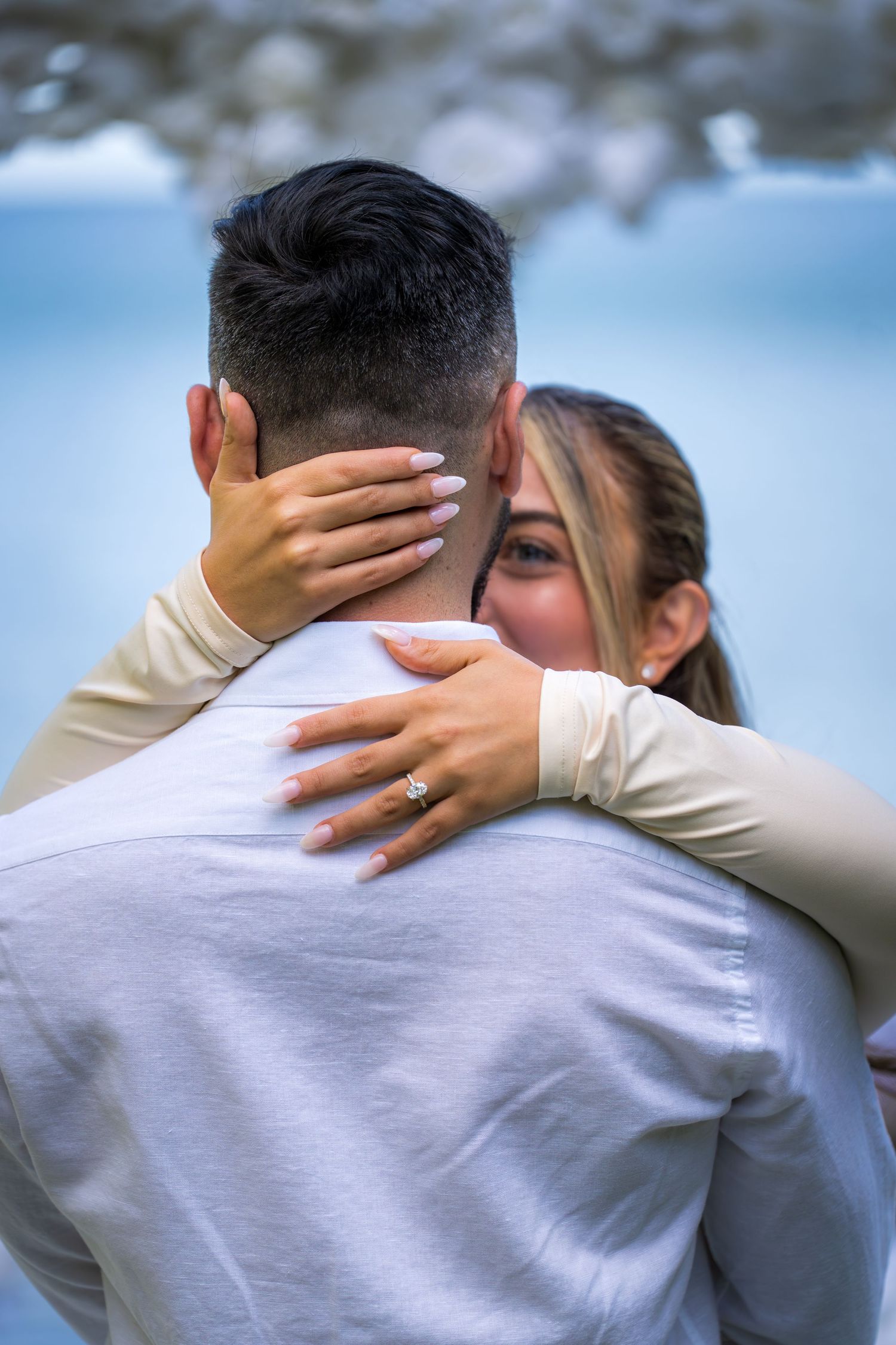 Close-up detail of embracing couple showing wedding ring.