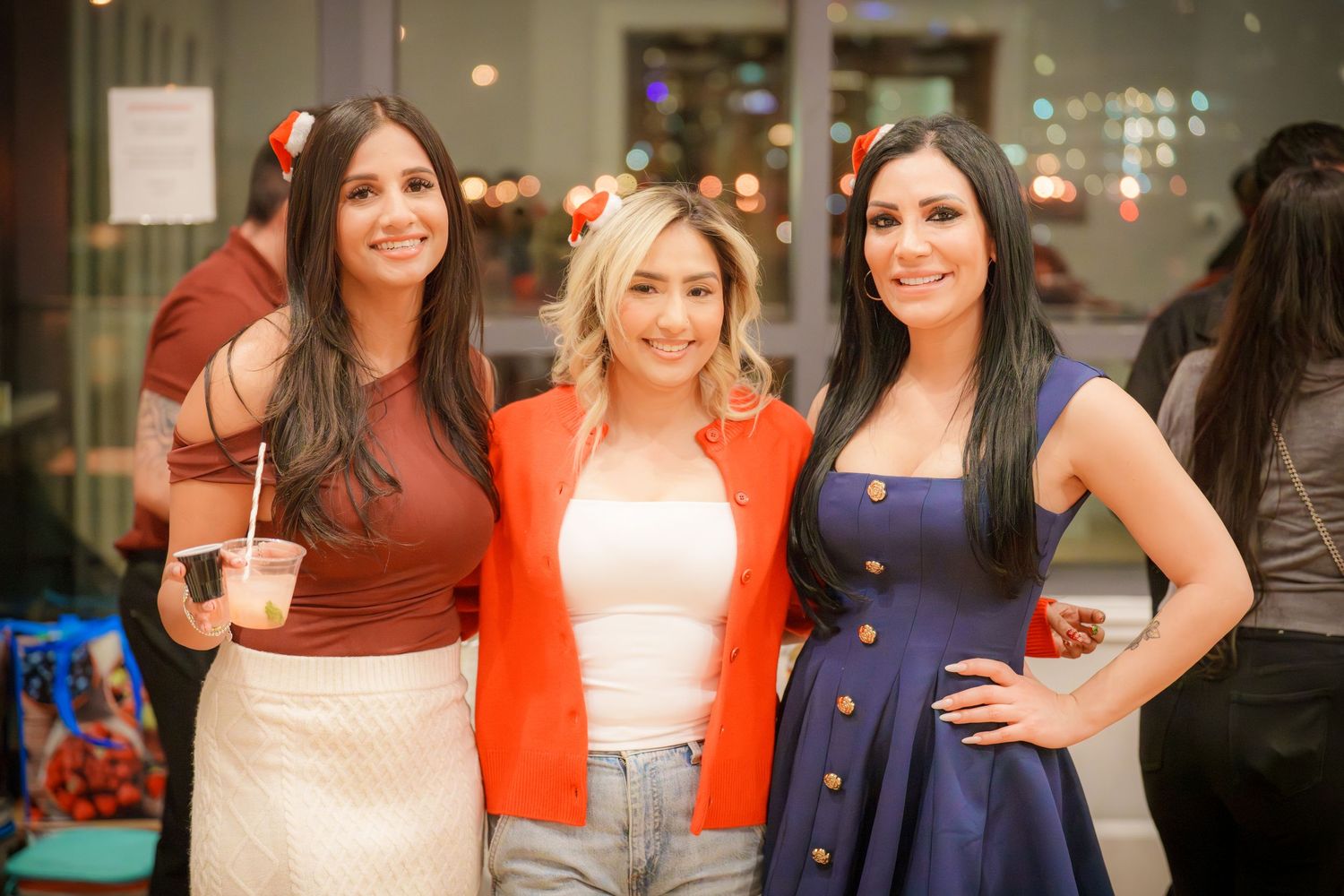 Friends posing together at a social gathering in casual party attire.