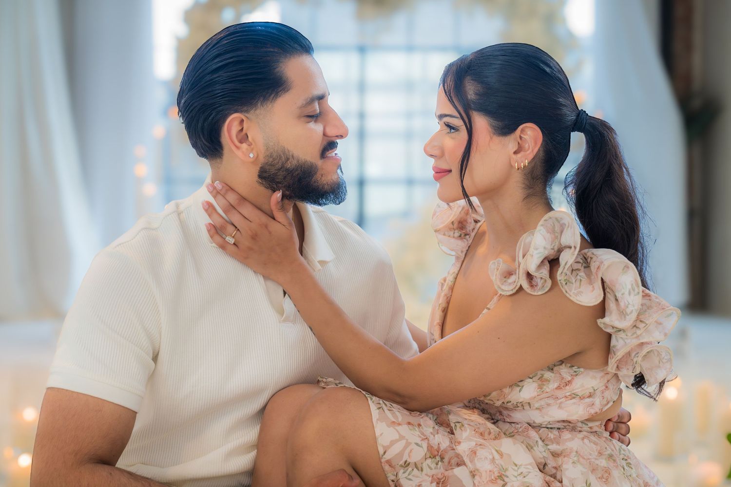 Engaged couple sharing an intimate moment, woman gently touching mans face during romantic proposal shoot.