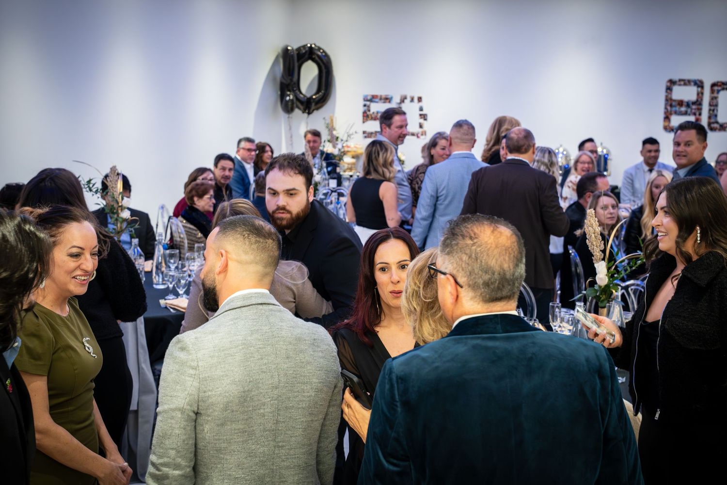 Guests mingling at an event with modern decor and lighting.
