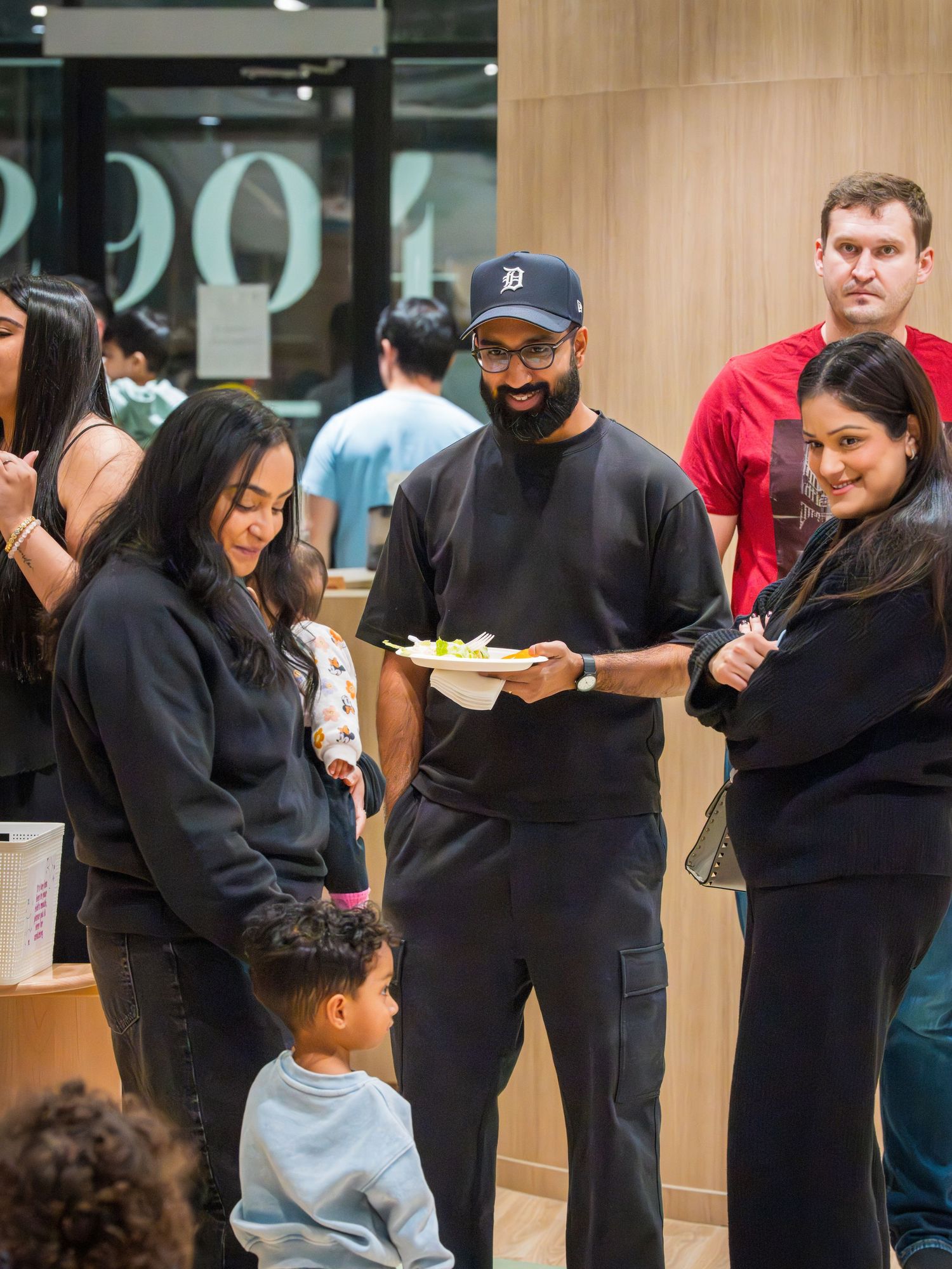 Group of friends socializing and sharing food at a casual indoor gathering event.