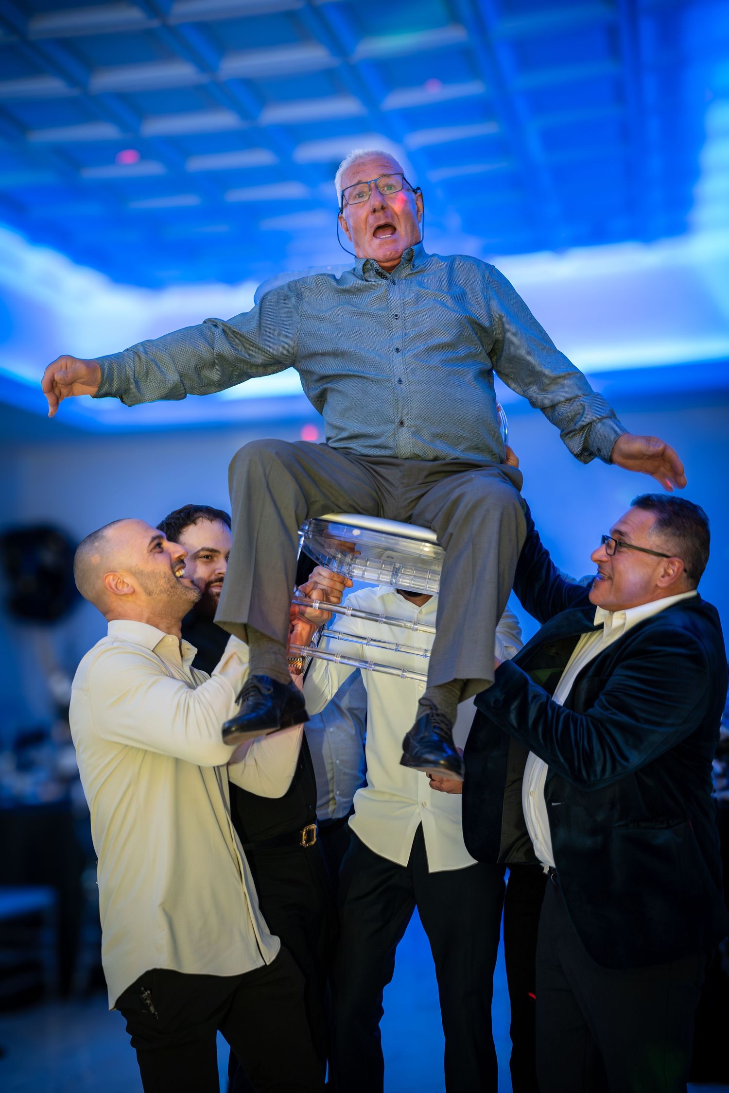 A group lifting and supporting someone during an entertaining moment at a party.